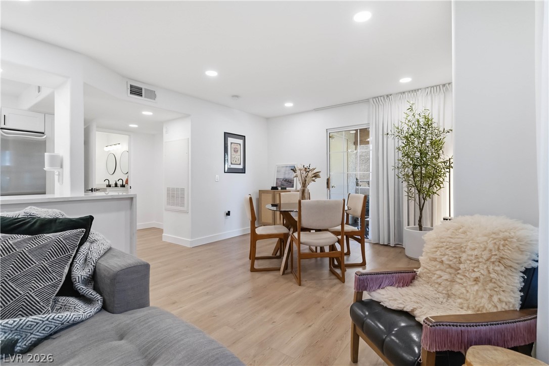 7950 West Flamingo Road, Unit 1180 Las Vegas, NV 89147 - Photo 26 of 26 The open floor plan seamlessly connects the kitchen to a bright dining area, featuring recessed lighting and durable wood flooring.