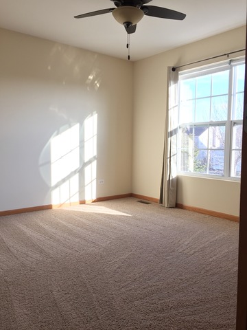562 Wynbrooke Road Romeoville, IL 60446 - Photo 14 of 24 an empty room with windows and ceiling fan