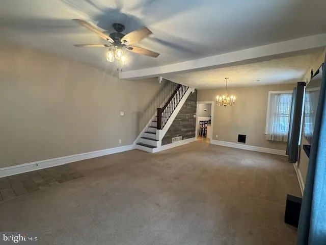 an empty room with staircase and white walls