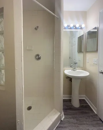 a bathroom with a sink shower and a mirror