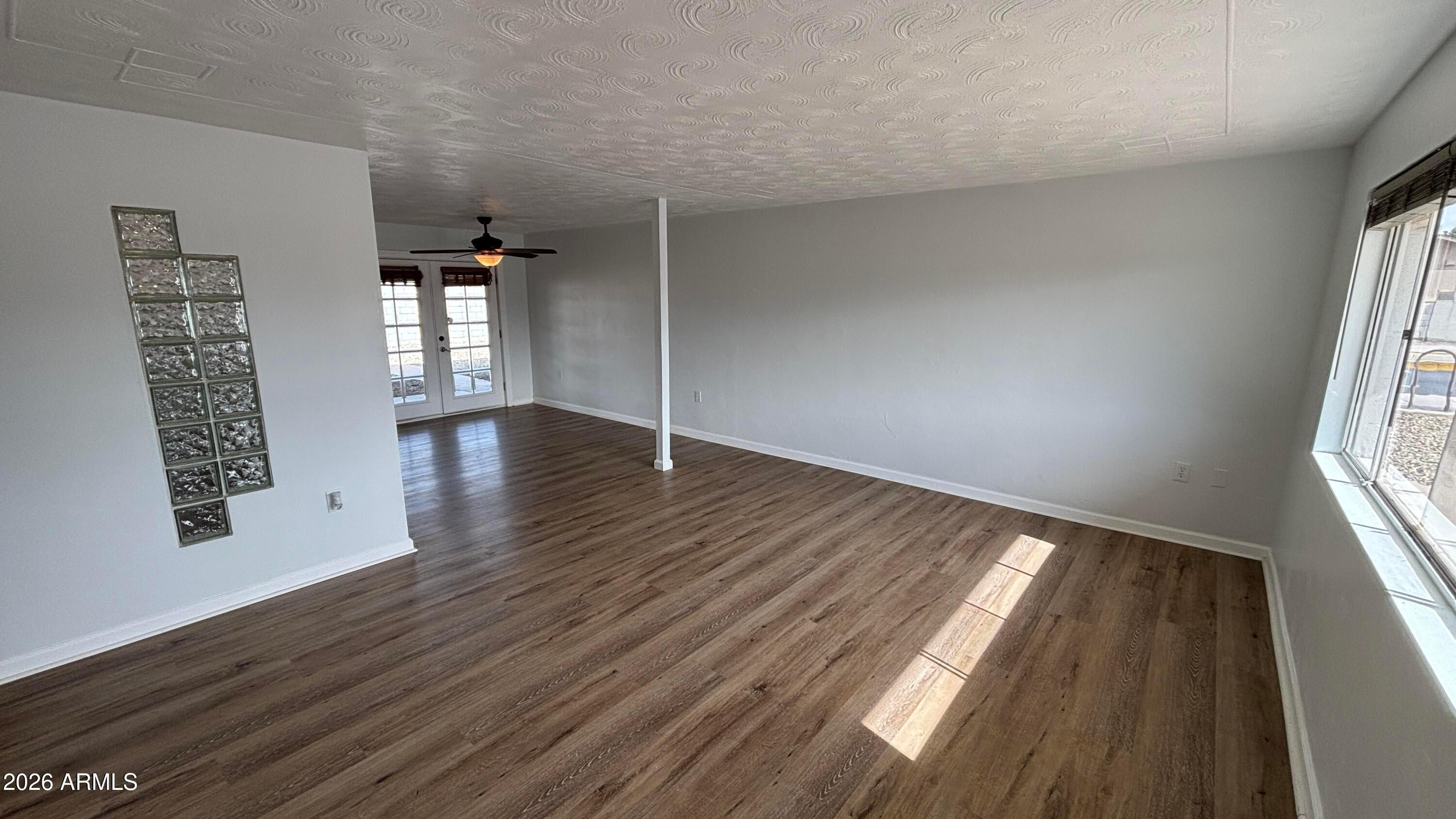 1000 West Elna Rae Street Tempe, AZ 85281 - Photo 3 of 22 an empty room with wooden floor and windows