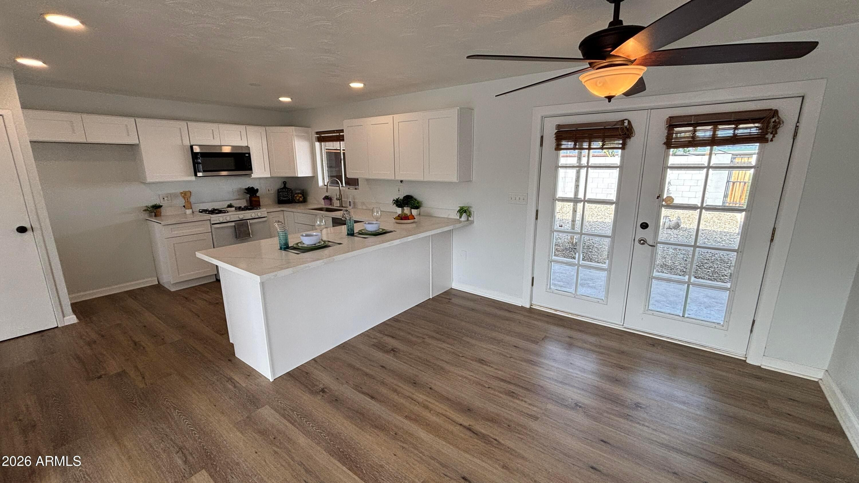 1000 West Elna Rae Street Tempe, AZ 85281 - Photo 5 of 22 a view of a kitchen with a sink wooden floor and a living room