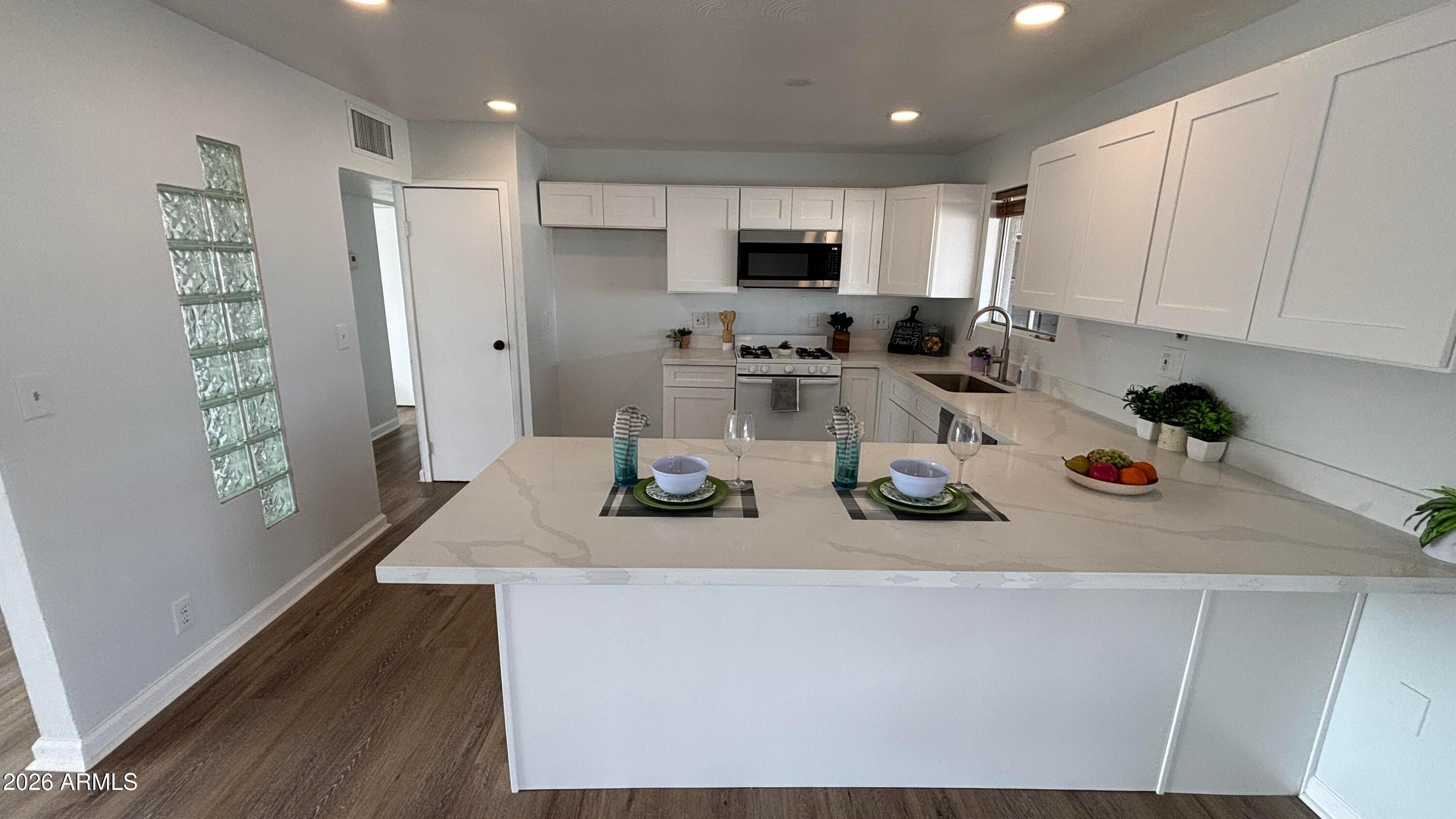 1000 West Elna Rae Street Tempe, AZ 85281 - Photo 6 of 22 a kitchen with a sink a stove and chairs