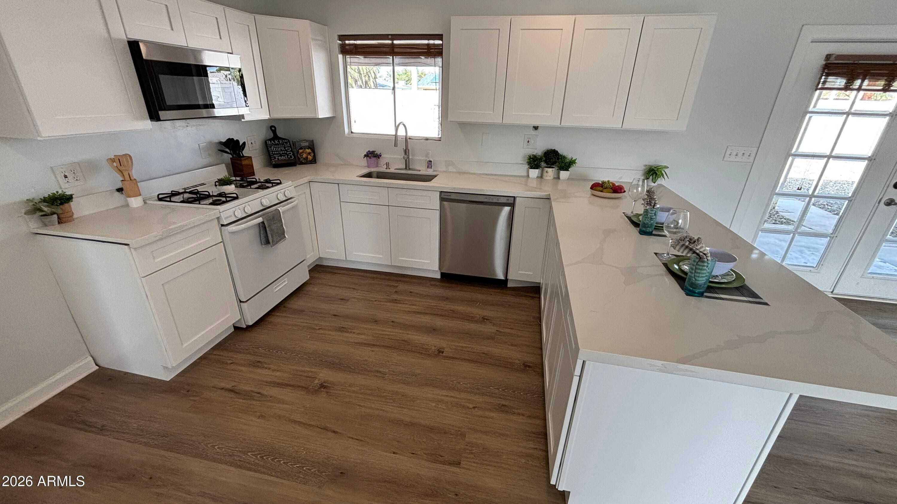 1000 West Elna Rae Street Tempe, AZ 85281 - Photo 7 of 22 a kitchen with white cabinets and appliances