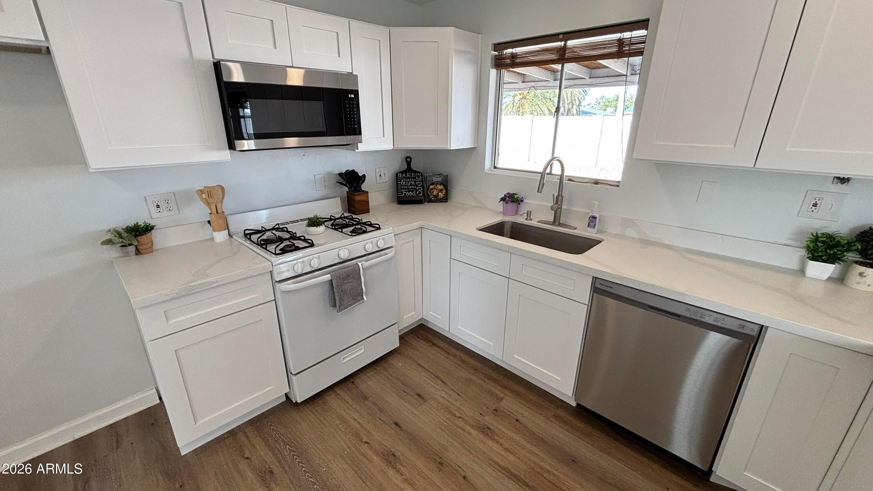 1000 West Elna Rae Street Tempe, AZ 85281 - Photo 8 of 22 a kitchen with white cabinets appliances a sink and a window