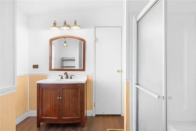 an empty room with wooden floor fireplace and windows