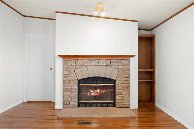 an empty room with chandelier fan and windows