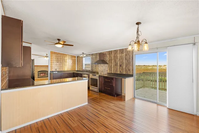 a kitchen with stainless steel appliances granite countertop a sink a stove and refrigerator