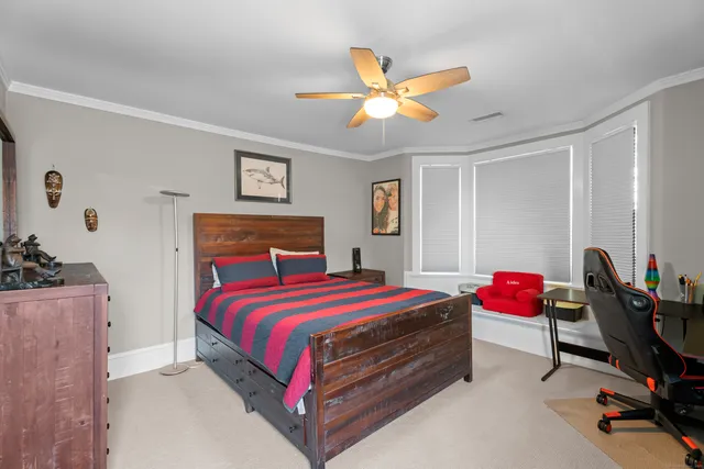 a bedroom with a bed a couch and a large window