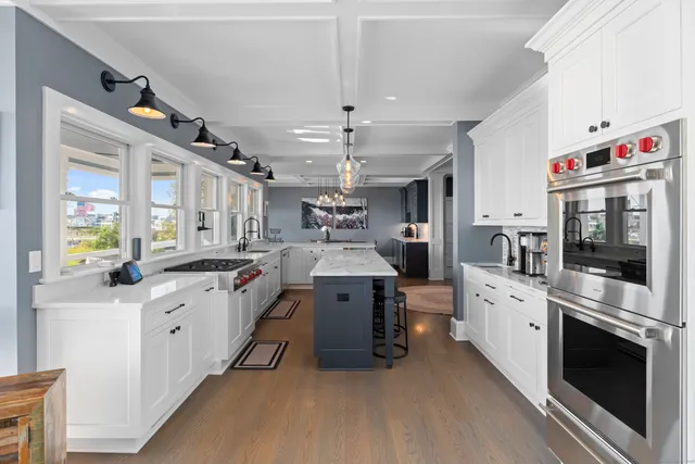 a large white kitchen with stainless steel appliances granite countertop lots of counter top space