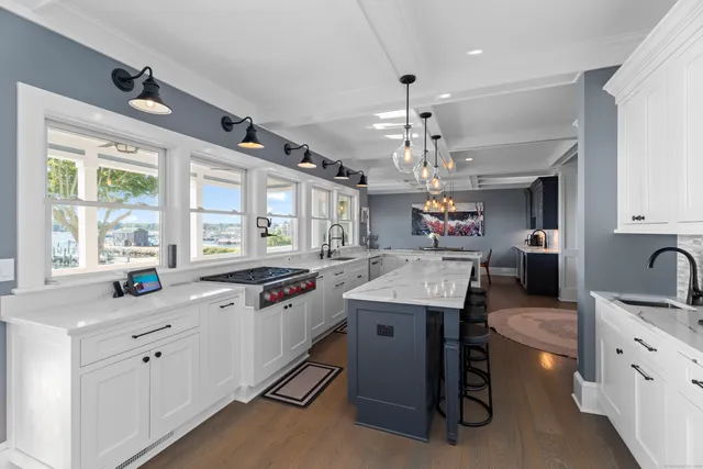 a kitchen with kitchen island granite countertop a sink stove and cabinets
