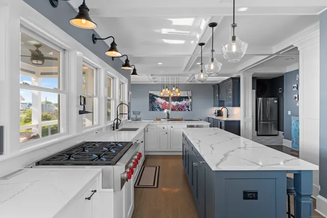 a large kitchen with a stove a sink a refrigerator dining table and chairs