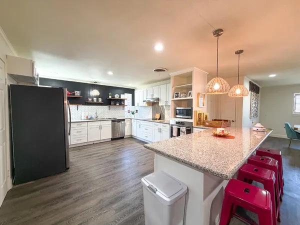 a kitchen with stainless steel appliances a refrigerator sink and wooden floor