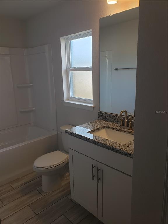 4858 Sutherland St Spring Hill, Unit LOT 61 Spring Hill, FL 34609 - Photo 11 of 15 a bathroom with a granite countertop sink toilet and a bathtub
