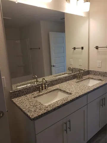 a bathroom with a granite countertop sink and a mirror