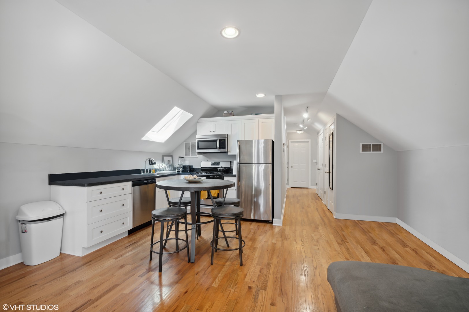 2458 North Lotus Avenue Chicago, IL 60639 - Photo 21 of 22 a kitchen with stainless steel appliances a refrigerator a stove a dining table and chairs with wooden floor