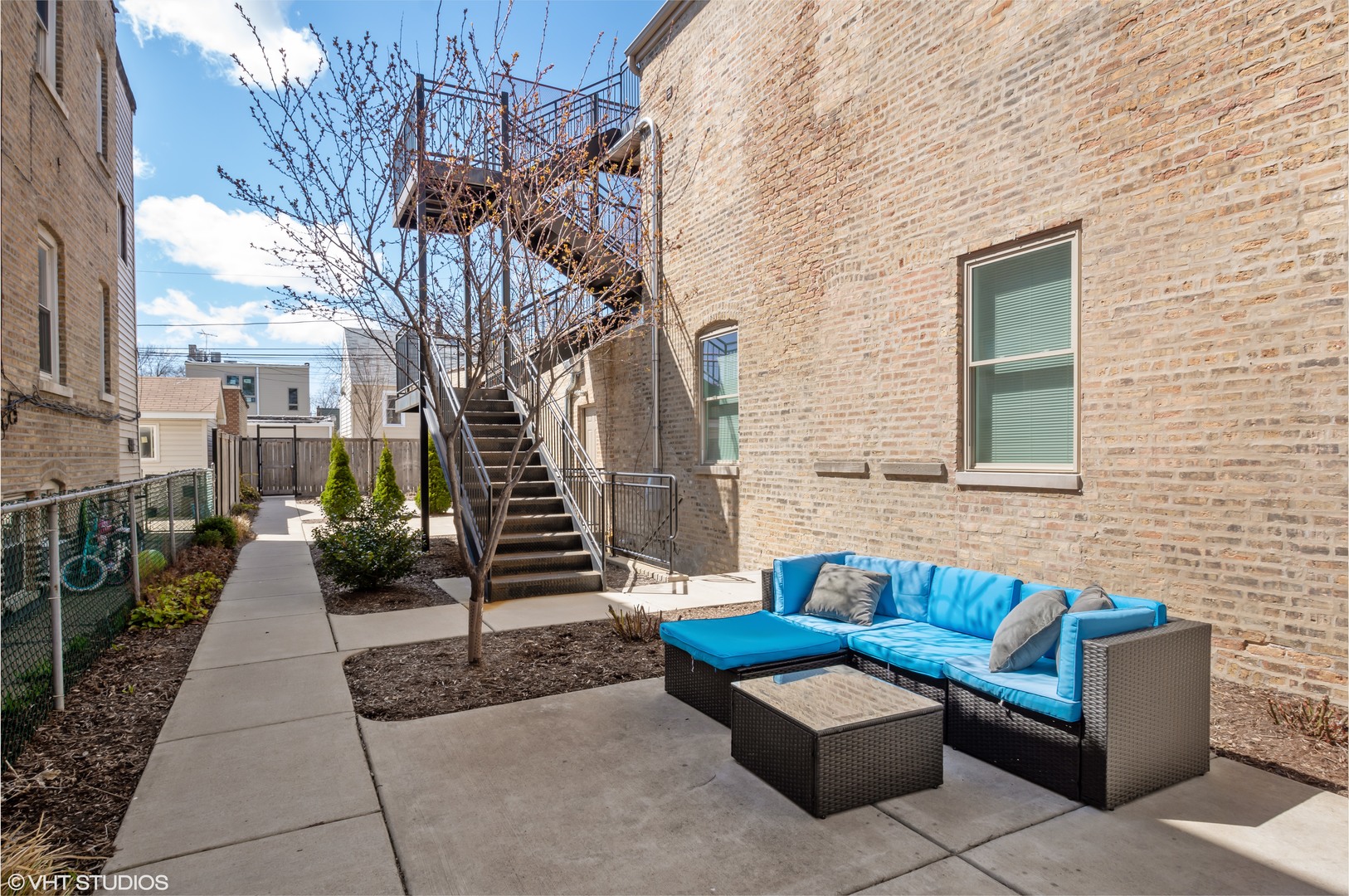 2458 North Lotus Avenue Chicago, IL 60639 - Photo 5 of 22 a view of a patio with couches and a fire pit and wooden fence