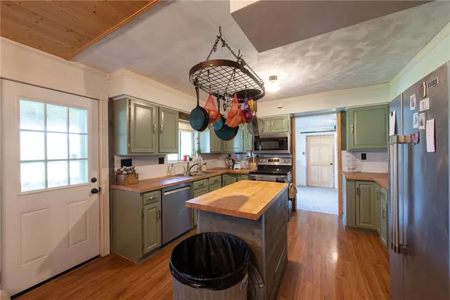 a kitchen with stainless steel appliances granite countertop a sink a stove a refrigerator and cabinets