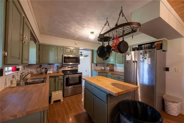 a kitchen that has a lot of cabinets and stainless steel appliances