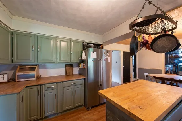a kitchen with stainless steel appliances granite countertop a sink dishwasher and a refrigerator with wooden floor