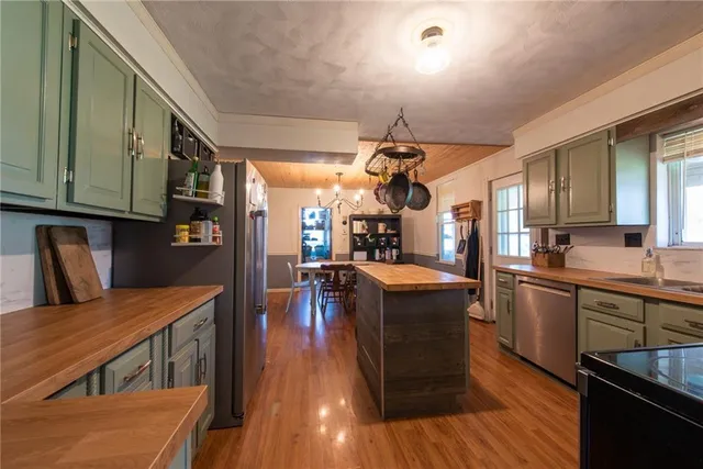 a kitchen with stainless steel appliances granite countertop wooden floors a stove and a sink
