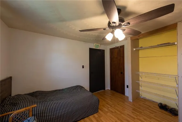 a bedroom with a bed and a ceiling fan