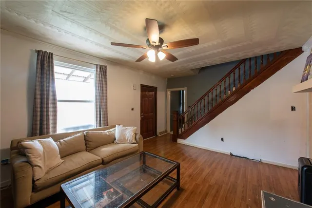 a living room with furniture and a ceiling fan