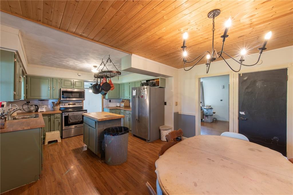 1182 State Rte 1035 Templeton, PA 16259 - Photo 7 of 50 a kitchen view with stainless steel appliances kitchen island granite countertop a table chairs and a wooden floor