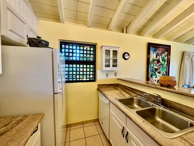 a kitchen that has a sink and a stove with wooden floor