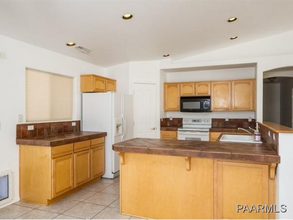 5732 Columbine Road Prescott, AZ 86305 - Photo 7 of 24 a kitchen with granite countertop a sink and a refrigerator