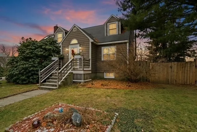 a view of a house with a small yard and a wooden fence
