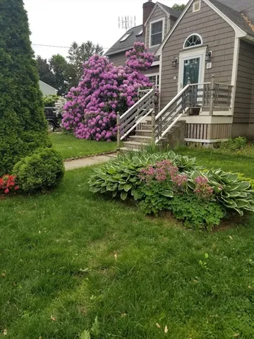 a front view of a house with a garden