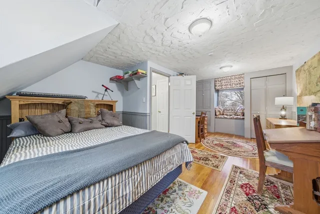 a bedroom with a large bed and a wooden floor