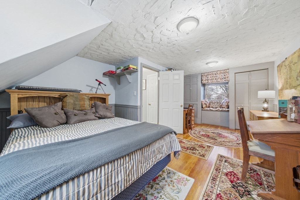 4 Laurel Street Woburn, MA 01801 - Photo 25 of 40 a bedroom with a large bed and a wooden floor