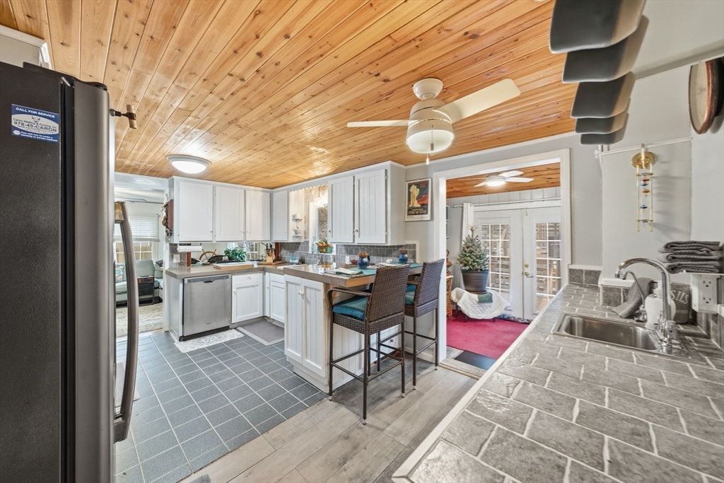 4 Laurel Street Woburn, MA 01801 - Photo 10 of 40 a kitchen view with stainless steel appliances granite countertop a stove a sink and cabinets