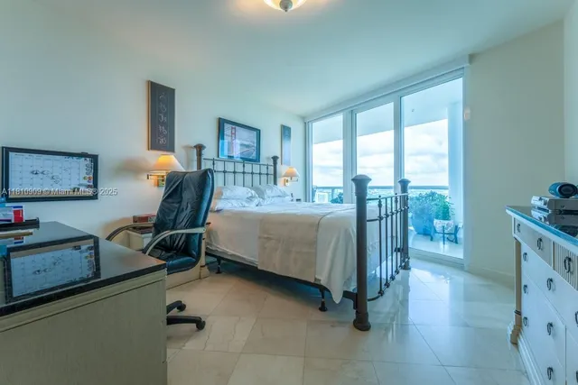 a bedroom with furniture and a large window