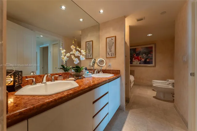 a bathroom with a granite countertop sink a large mirror and a toilet