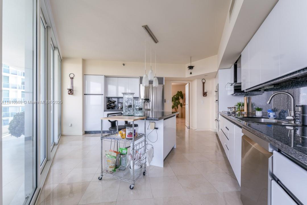 2127 Brickell Avenue, Unit 3304 Miami, FL 33129 - Photo 8 of 39 a kitchen with stainless steel appliances kitchen island granite countertop a refrigerator and a sink