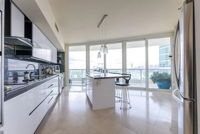 a kitchen with a large window and a view of living room