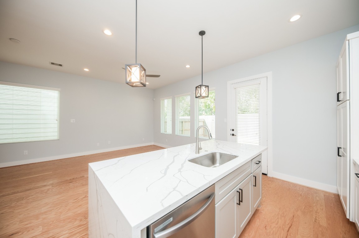 1860 West Tidwell Road Houston, TX 77091 - Photo 13 of 32 a kitchen with a sink chandelier and wooden floor