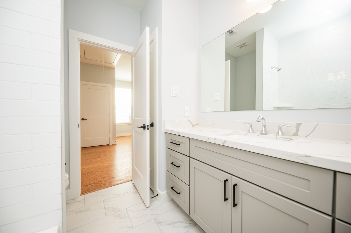 1860 West Tidwell Road Houston, TX 77091 - Photo 22 of 32 a spacious bathroom with a granite countertop sink and a mirror