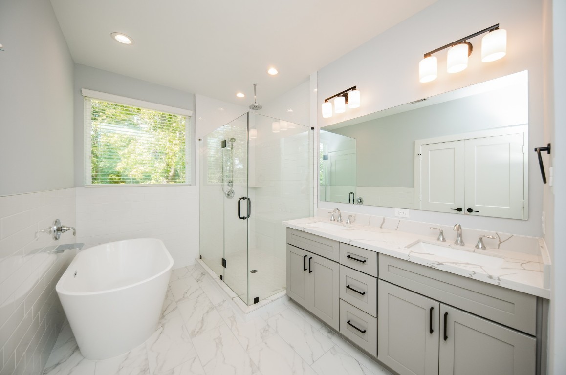 1860 West Tidwell Road Houston, TX 77091 - Photo 29 of 32 a spacious bathroom with a double vanity sink a mirror and a bathtub