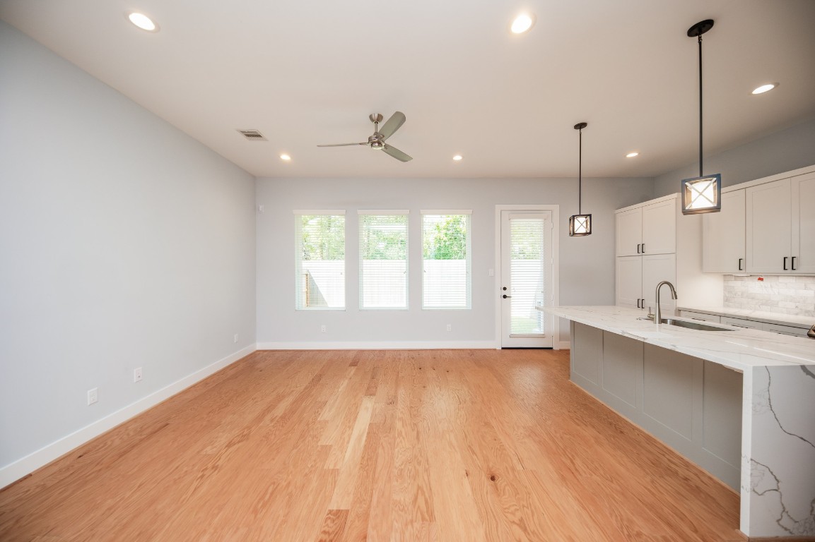 1860 West Tidwell Road Houston, TX 77091 - Photo 10 of 32 a large kitchen with kitchen island a sink wooden floor and a chandelier