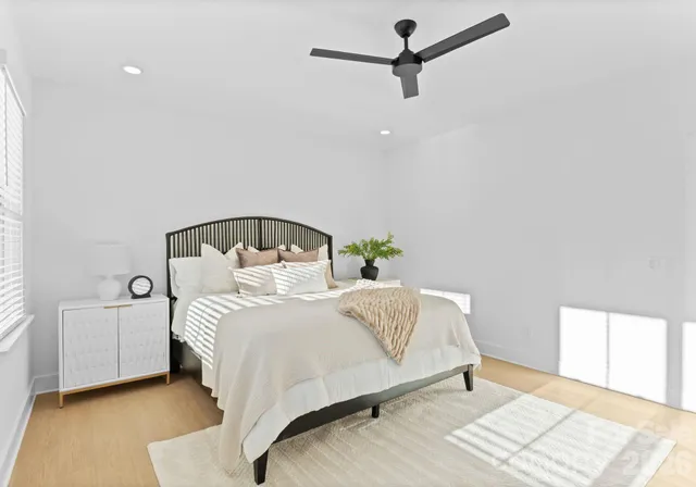 a bedroom with a bed next to a window with a chandelier