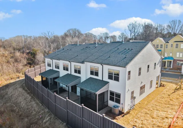 a view of a house with wooden deck and a couple of houses