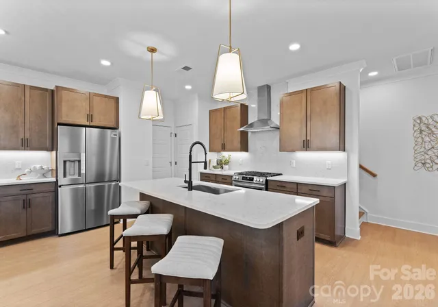 a kitchen with stainless steel appliances granite countertop a sink stove and refrigerator