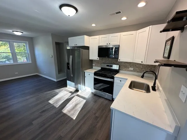 a kitchen with stainless steel appliances a refrigerator sink and microwave