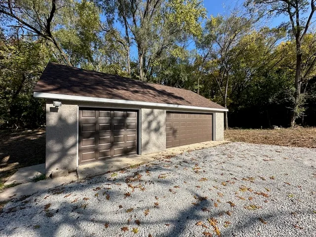 a backyard of a house with large trees and empty space