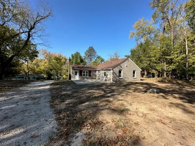a view of house with backyard and trees