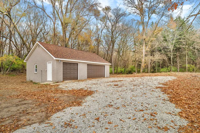 a front view of house with yard and trees around